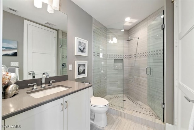 bathroom with walk in shower, vanity, and toilet