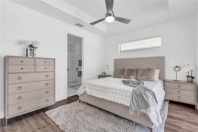 bedroom featuring ensuite bath, dark hardwood / wood-style floors, and ceiling fan