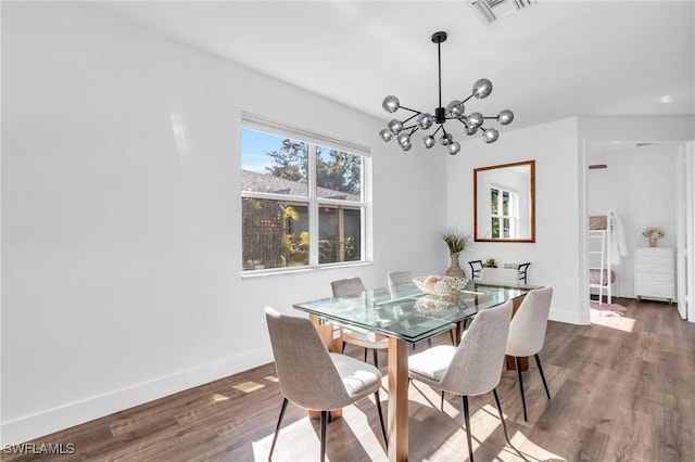 dining area featuring dark wood-type flooring and a notable chandelier