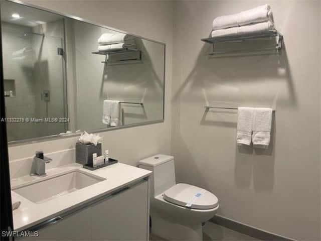 bathroom featuring toilet, vanity, and walk in shower