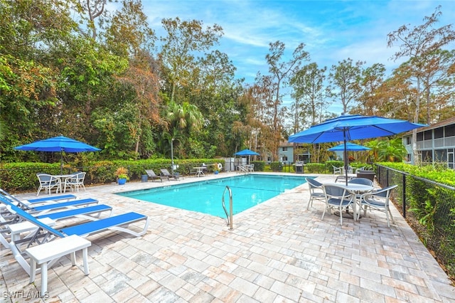 community pool with fence and a patio