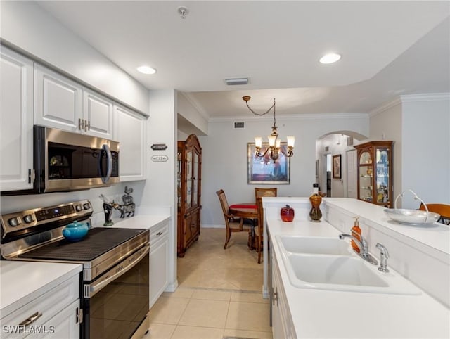 kitchen with sink, crown molding, hanging light fixtures, stainless steel appliances, and white cabinets