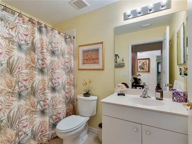 bathroom featuring vanity, tile patterned floors, and toilet