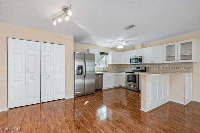 kitchen featuring sink, white cabinetry, backsplash, stainless steel appliances, and dark hardwood / wood-style flooring