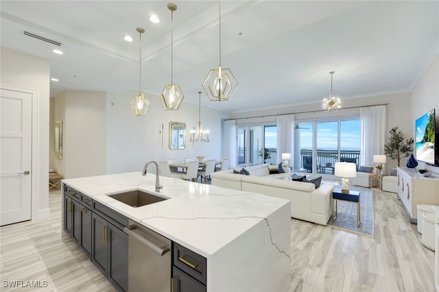 kitchen with an inviting chandelier, stainless steel dishwasher, sink, and hanging light fixtures