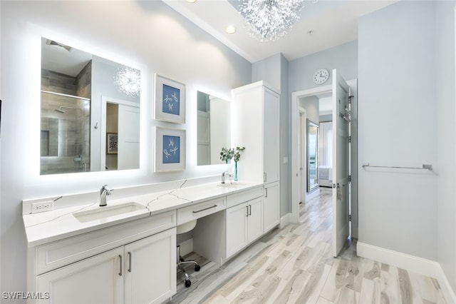 bathroom with vanity, a shower with shower door, and wood-type flooring