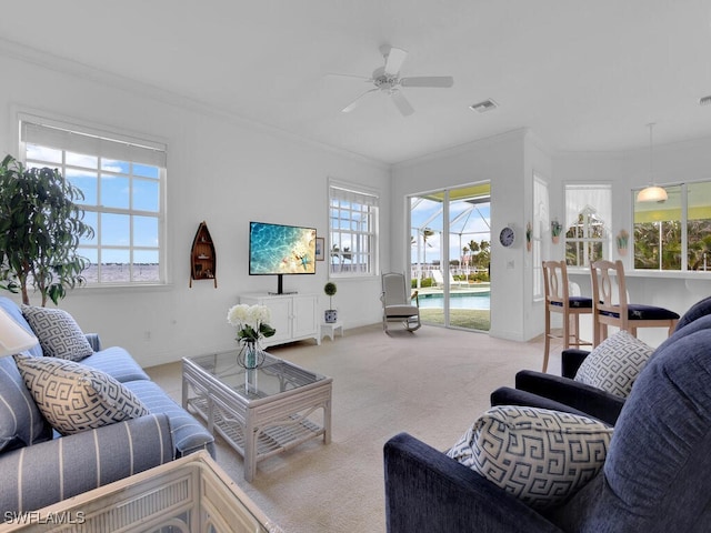 living room with crown molding, ceiling fan, and light carpet