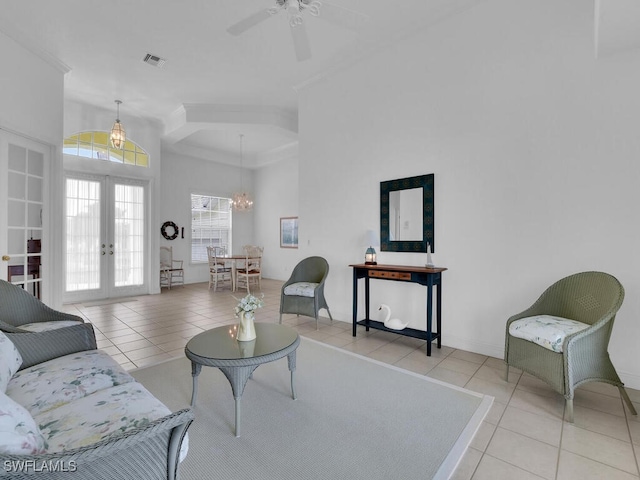 living room featuring ceiling fan with notable chandelier, french doors, and light tile patterned flooring