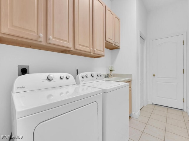 laundry area with cabinets, separate washer and dryer, sink, and light tile patterned floors