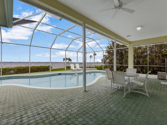 view of pool featuring a patio, a water view, and glass enclosure