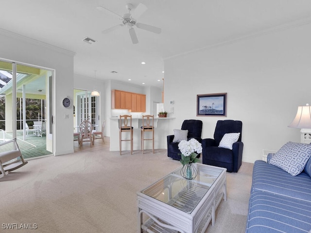 living room featuring ceiling fan, ornamental molding, and light colored carpet