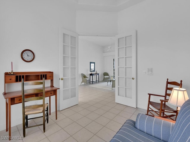 sitting room with french doors, a high ceiling, and light tile patterned flooring