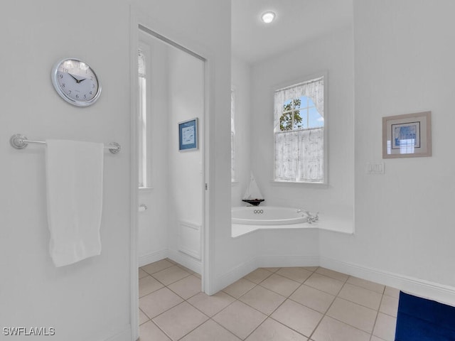 bathroom with a washtub and tile patterned floors