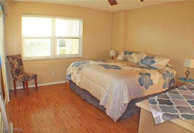 bedroom with wood finished floors, a ceiling fan, and baseboards