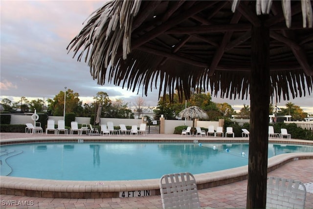 community pool with a patio area and fence