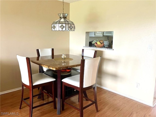 dining area featuring baseboards and wood finished floors