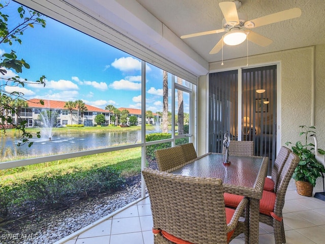 sunroom featuring a water view and ceiling fan