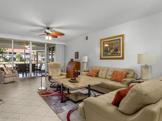 tiled living room featuring expansive windows and ceiling fan