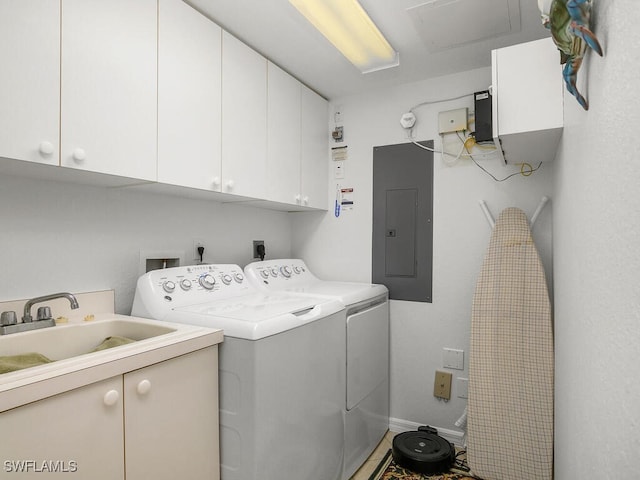 laundry area with sink, electric panel, cabinets, and washing machine and clothes dryer