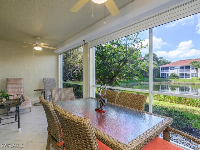 sunroom with a water view and ceiling fan