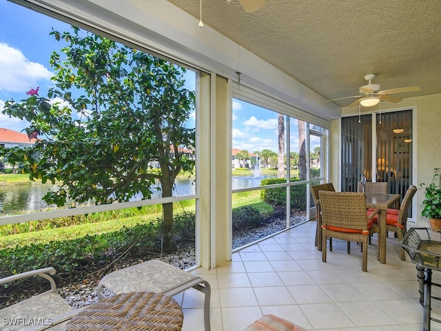 sunroom / solarium with a water view and ceiling fan