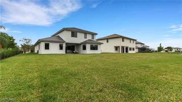 rear view of property with a lawn