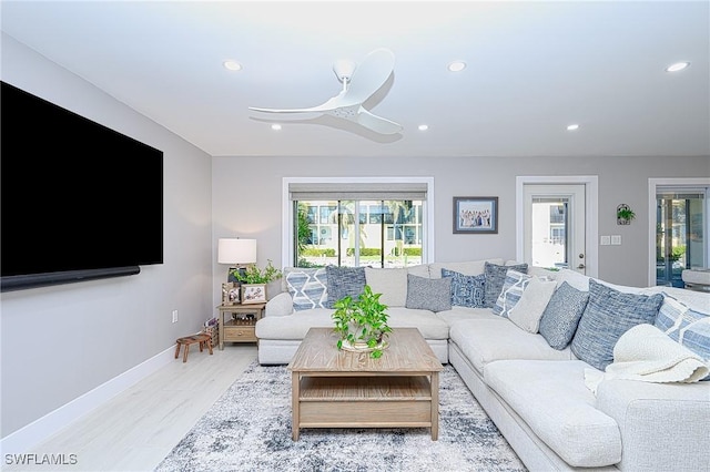 living room featuring ceiling fan and light hardwood / wood-style flooring