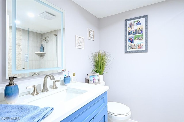 bathroom featuring vanity, toilet, and tiled shower