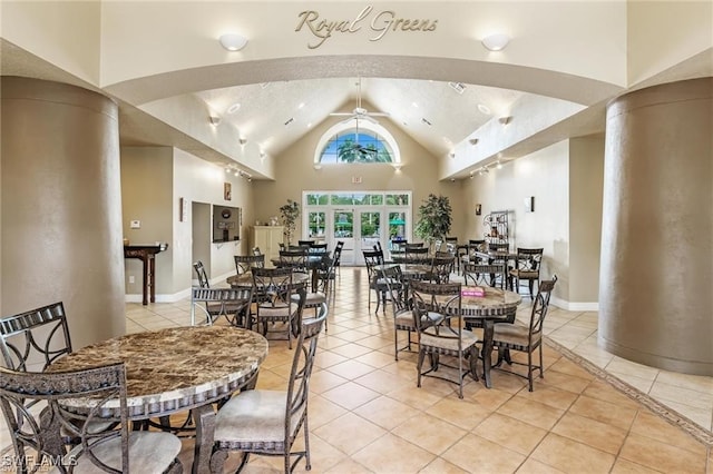 dining area with ceiling fan, light tile patterned floors, and high vaulted ceiling