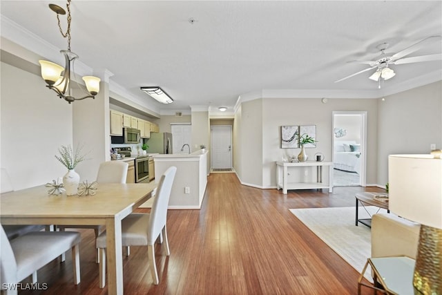 dining room featuring hardwood / wood-style flooring, crown molding, and ceiling fan with notable chandelier