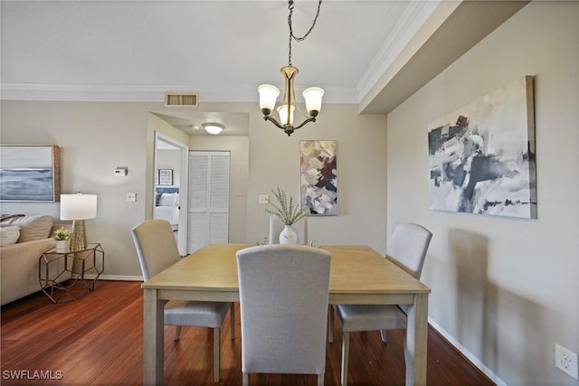 dining room with ornamental molding, dark hardwood / wood-style floors, and a notable chandelier