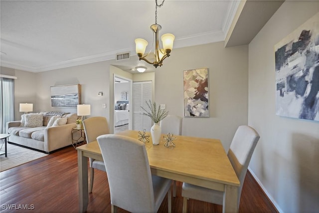 dining room with dark hardwood / wood-style flooring, a notable chandelier, and crown molding