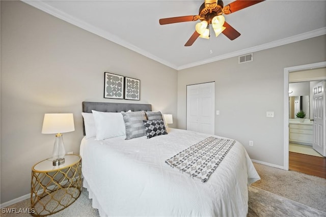 bedroom with crown molding, ceiling fan, carpet flooring, and a closet