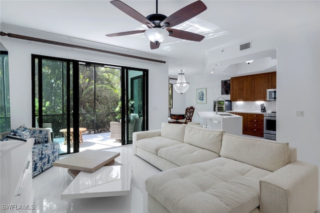 living room featuring ornamental molding, sink, and ceiling fan with notable chandelier