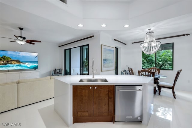 kitchen with ceiling fan with notable chandelier, decorative light fixtures, sink, a kitchen island with sink, and stainless steel dishwasher