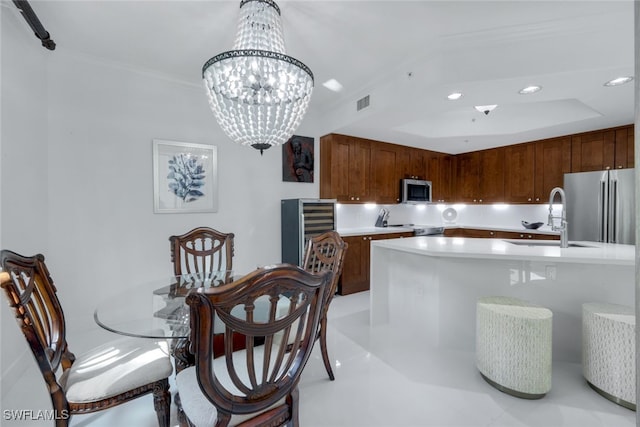 kitchen with a kitchen island with sink, sink, stainless steel appliances, and hanging light fixtures