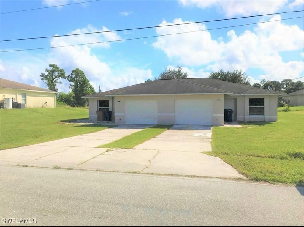 single story home with a garage and a front yard