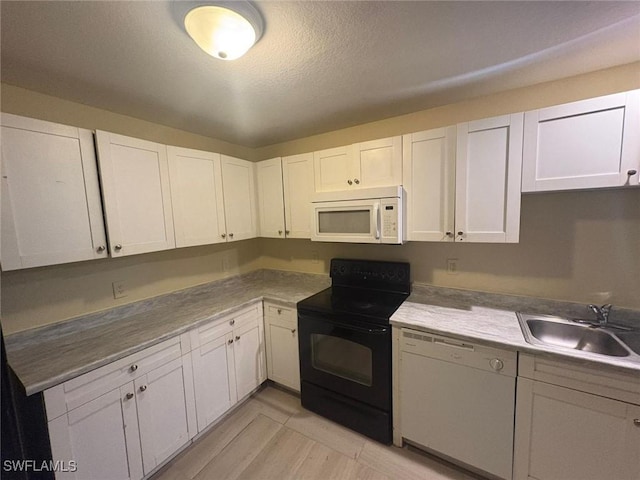 kitchen with white cabinetry, sink, and white appliances