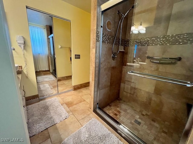 bathroom featuring a shower stall and baseboards