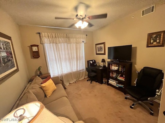 living room with carpet floors, visible vents, a textured ceiling, and a ceiling fan