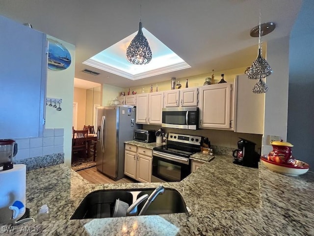 kitchen with pendant lighting, stainless steel appliances, white cabinetry, a sink, and light stone countertops