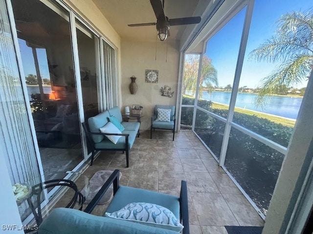 sunroom with ceiling fan and a water view