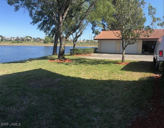 view of yard with a garage and a water view