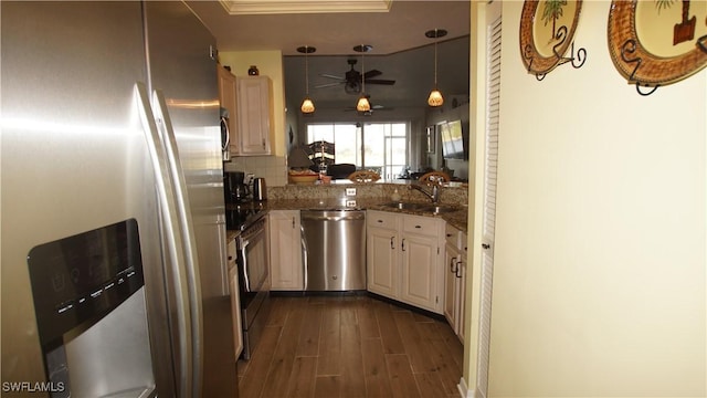 kitchen featuring ceiling fan, dark wood-type flooring, a sink, appliances with stainless steel finishes, and tasteful backsplash