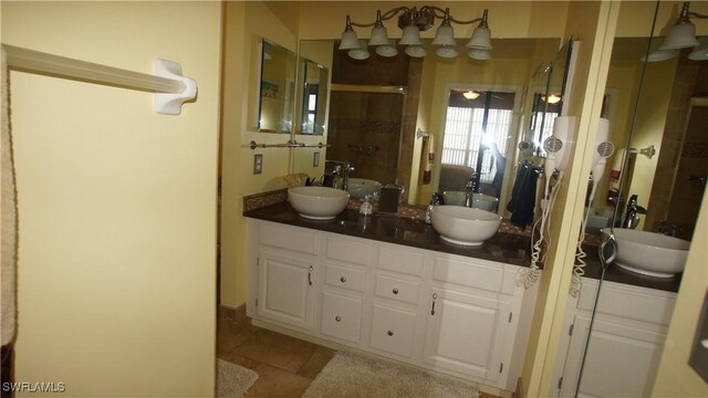 bathroom with double vanity, a sink, and a shower stall