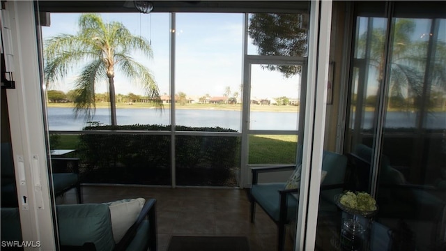 sunroom / solarium featuring a water view