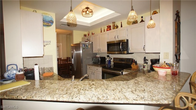 kitchen featuring stainless steel appliances, a peninsula, backsplash, light stone countertops, and a raised ceiling