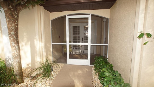 entrance to property featuring stucco siding