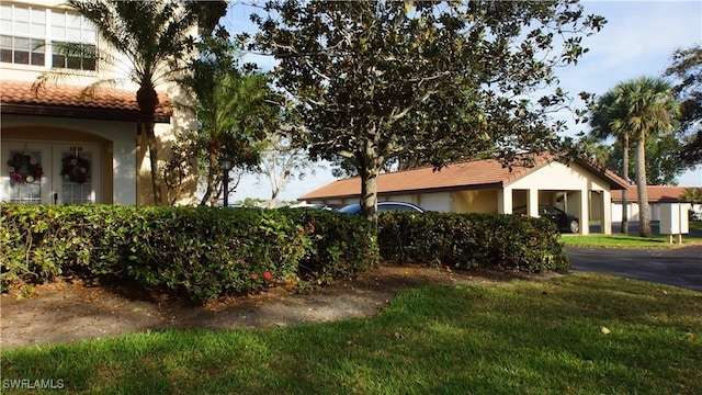 view of property exterior with a tile roof and a lawn