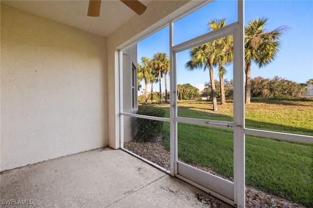 unfurnished sunroom featuring ceiling fan